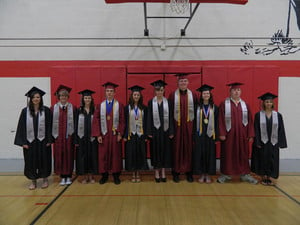 Class of 2013 in caps & gowns in gym