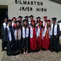 Class of 2016 standing outside the MS/HS building in their caps & gowns